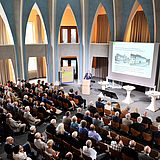 Personen in einem Saal bei einer Präsentation