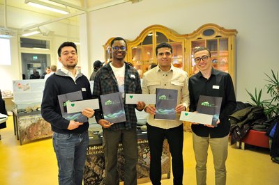 Vier Studierende präsentieren ihre Urkunden. 