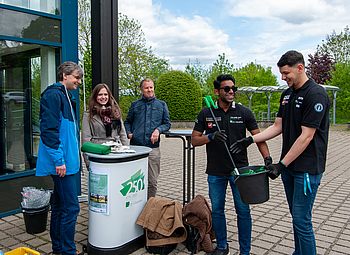 Müllsäcke und Greifzangen für die Aktion werden an Freiwillige übergeben.