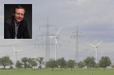 Stromnetze und Windräder in der Landschaft. In das Bild integriert ist ein kleines Porträtfoto eines Mannes.
