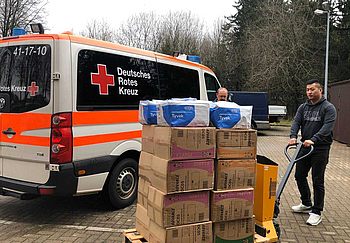 Eine Person transportiert Spenden für das Deutsche Rote Kreuz
