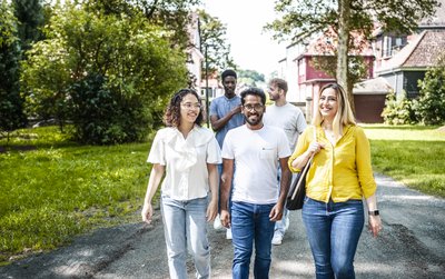 Fünf Studierende laufen über den Campus der TU Clausthal. 
