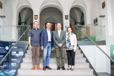 Gruppenbild mit vier Personen auf der Treppe. 