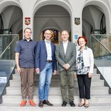 Gruppenbild mit vier Personen auf der Treppe. 