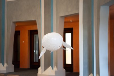 Eine Art Luftballon, der ferngesteuert wid, fliegt durch einen Festsaal. 