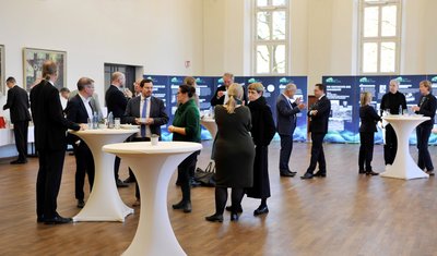 Zahlreiche Personen im Umfeld einer Ausstellung. 