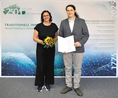 Präsidentin überreicht dem neuen Professor die Urkunde. 