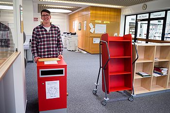 Eine Person steht hinter einer Zeitkapsel-Box 