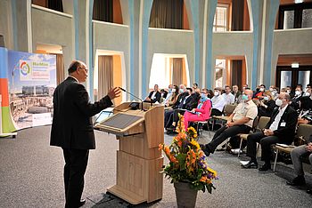 Person an einem Rednerpult hält eine Präsentation 