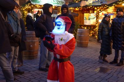 Humanoider Roboter klatscht auf einem Weihnachtsmarkt. 