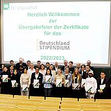Übergabezeremonie des Deutschlandstipendiums mit Studierenden, die ihre Zertifikate in einem Hörsaal halten