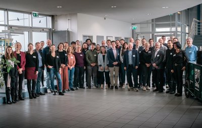 Gruppe von rund 40 Menschen im Inneren eines Gebäudes. 