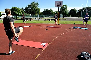 Personen trainieren auf einem Basketballplatz 