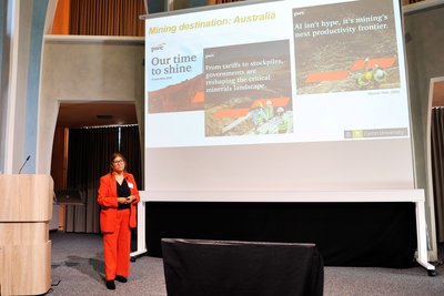 Eine Referentin im roten Hosenanzug steht in der Clausthaler Aula. 