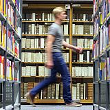 Ein Studierender geht durch die Universitätsbibliothek
