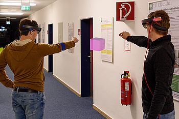 Zwei Personen mit Augmented-Reality-Brille schauen auf einen Würfel
