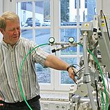 Drei Personen schauen auf ein Gerät