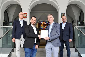 Zwei Personen mit einem Dokument in der Hand stehen auf der Treppe