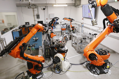 Blick in eine Technikumshalle mit mehreren Robotersystemen.  