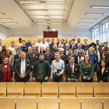 Gruppe mit rund 50 Personen im Hörsaal. 