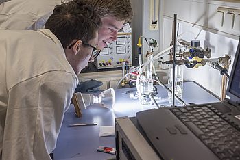 Zwei Studenten untersuchen eine Probe in einem Experiment