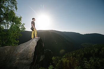 Eine Person steht auf einem großen Felsen 