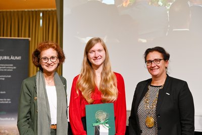 Absolventin mit ihrer Urkunde.