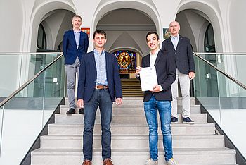 Vier Personen stehen auf einer Treppe