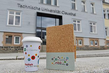 Notebook und Becher vor dem Hauptgebäude der TU Clausthal
