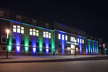 TU Clausthal Hauptgebäude am Abend mit farbigen Lichtern