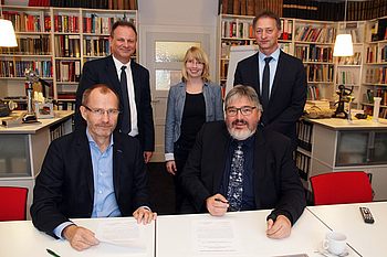 Zwei Personen unterschreiben ein Dokument