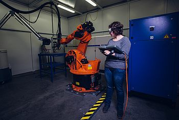 Eine Person bedient einen Roboterarm 