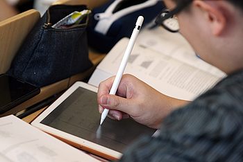 Eine Person schreibt mit einem Stift auf ihr iPad 
