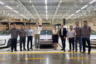 Eine Gruppe besucht eine Ausstellungshalle eines Autoherstellers. 