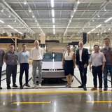 Eine Gruppe besucht eine Ausstellungshalle eines Autoherstellers. 